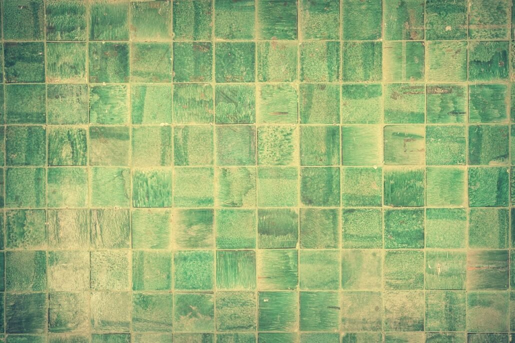 bathroom squeegee wiping water off tiled wall after shower