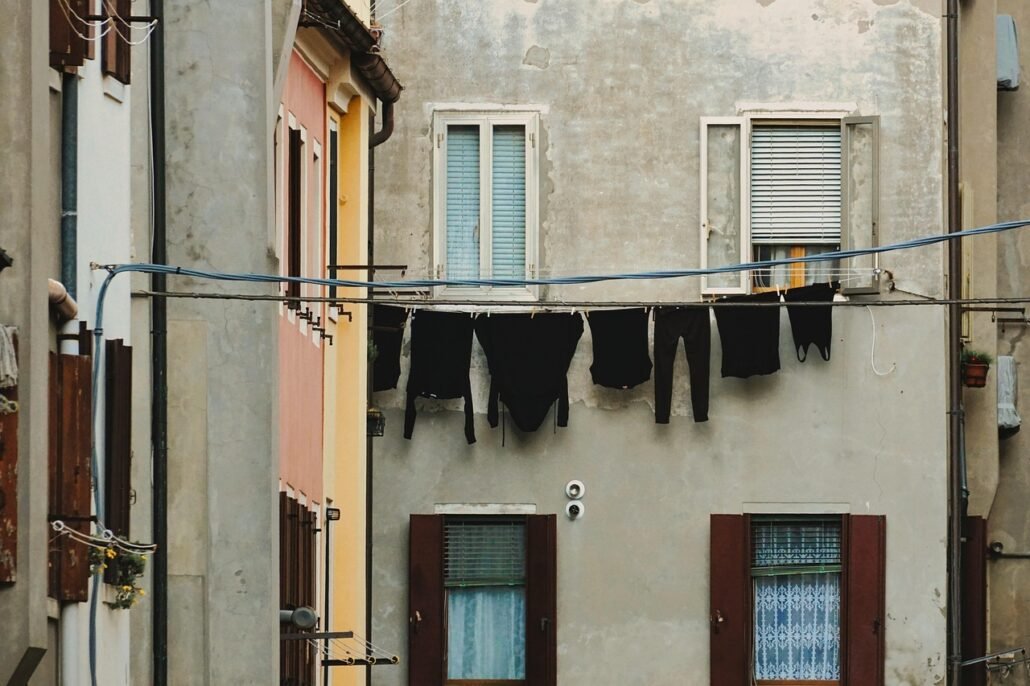 woman wiping window frame with cloth before applying weatherstrip, preparation step
